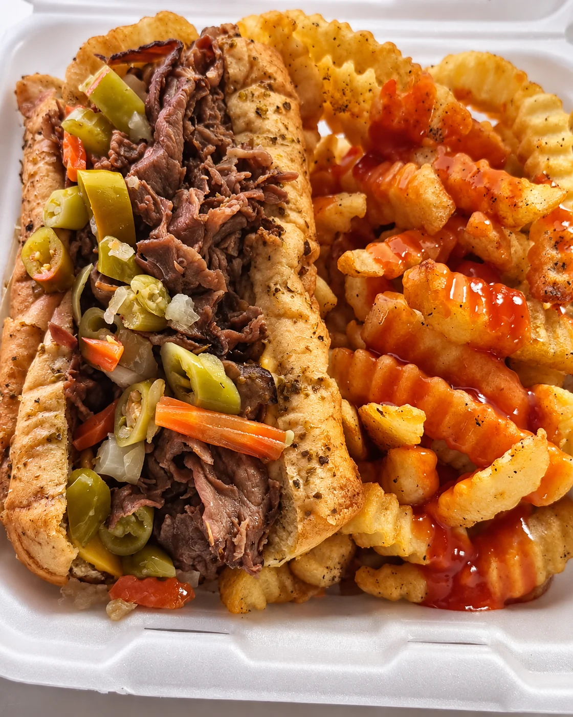 Chi Spot Italian beef sandwich with giardiniera and sauced crinkle fries