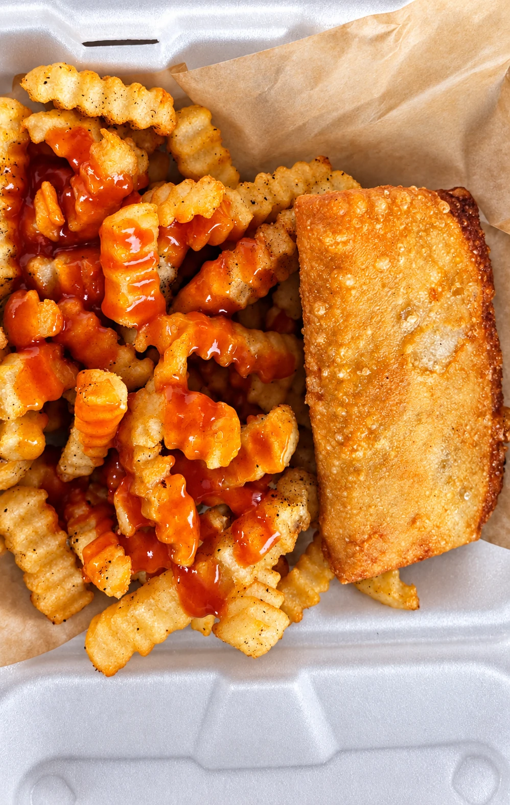 Ms. Daisy Struggle Pizza Puff with sauced crinkle fries